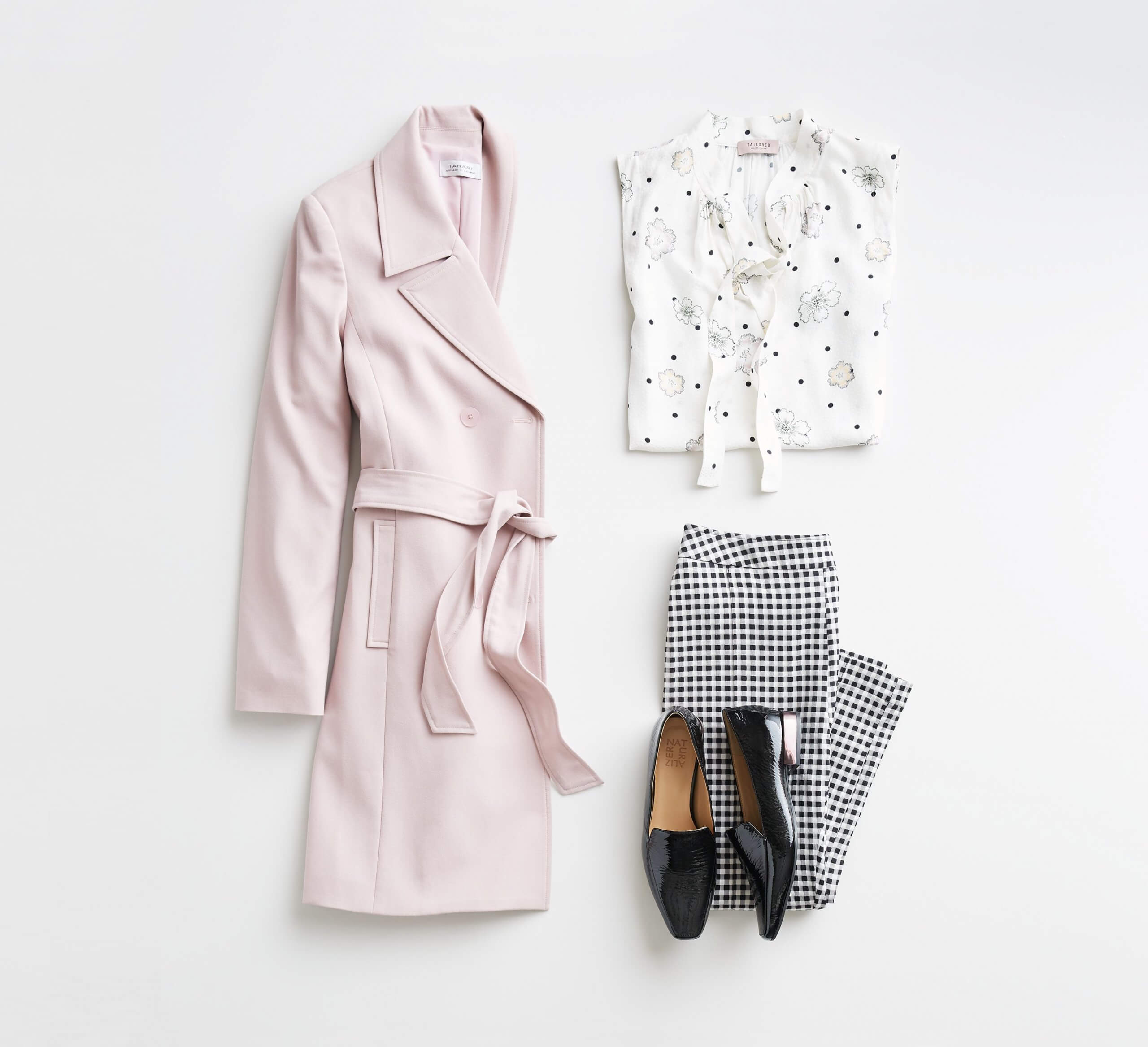 Stitch Fix Women’s outfit laydown featuring pink trench jacket, white patterned tie-neck blouse, black and white checkered pants and black loafers.