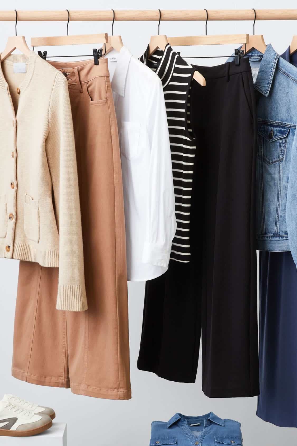 Hanging Stitch Fix womens clothes including beige sweater, striped tank and denim jacket.