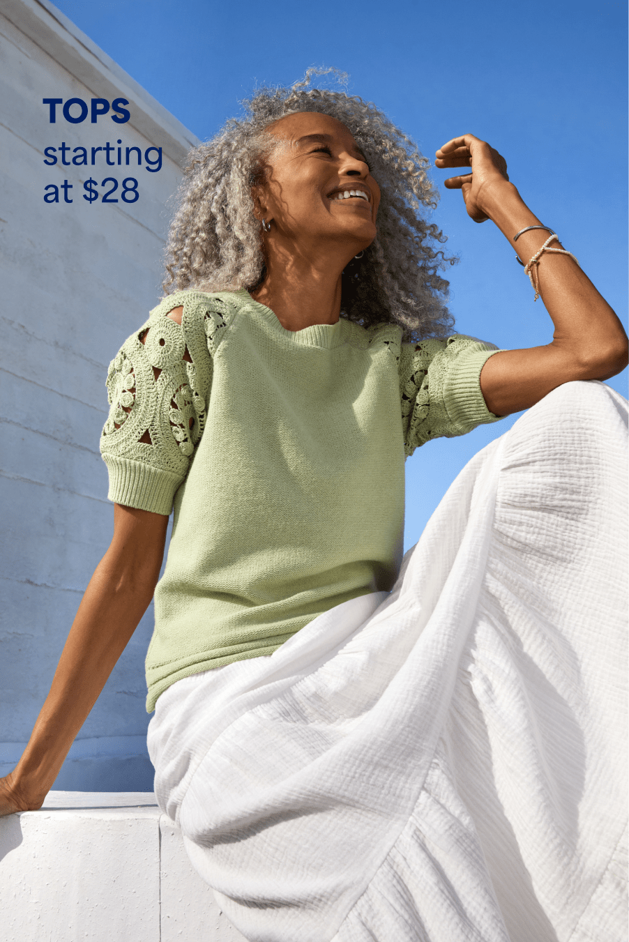 Woman wearing Stitch Fix clothing: green knit short-sleeve sweater, white maxi skirt. TOPS starting at $28.